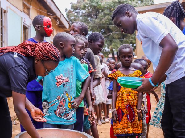 Volunteers serving a line of children