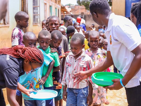 Volunteers serving children in a busy line