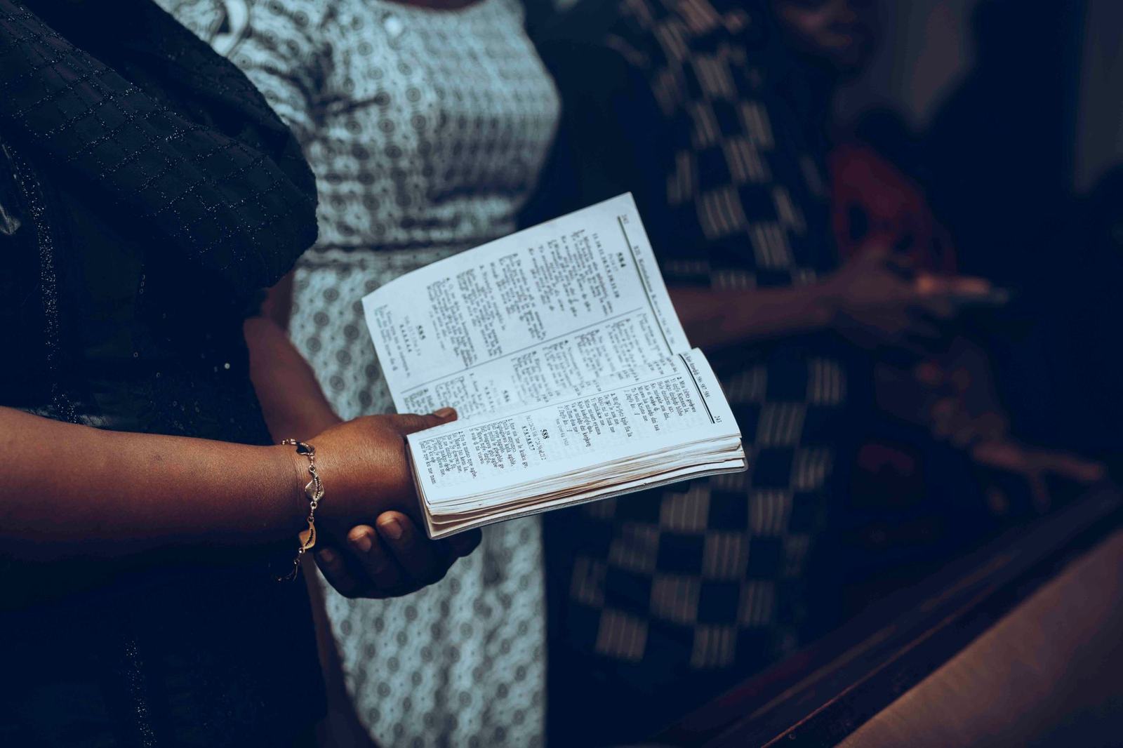 Members of a congregation holding a hymn book during a service