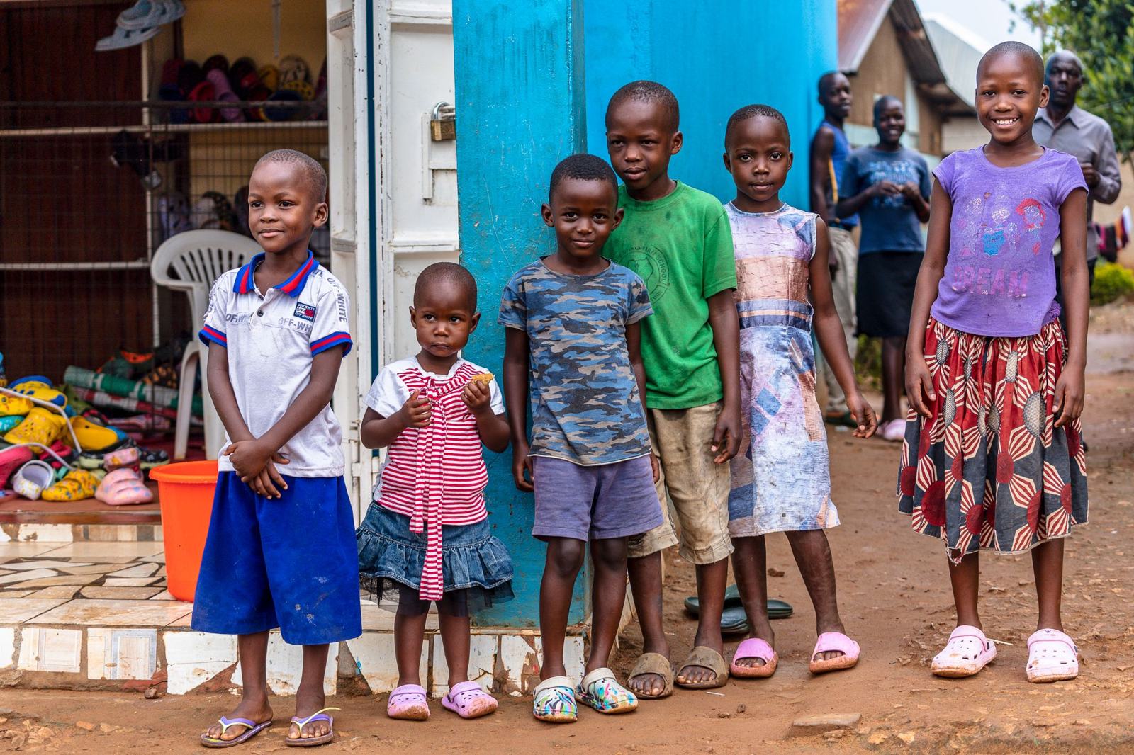 A group of smiling children standing outdoors in bright clothes